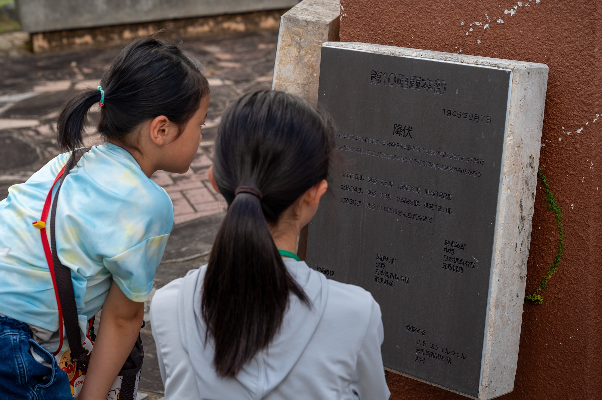 Achi-Mura students reading a plaque located at the Peace Garden in Kadena Air Base