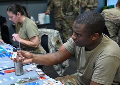 U.S. Air Force Maj. Quinton Kennedy, 30th Student Squadron, Squadron Officer School flight commander and instructor, shows a card to his opponent in an Air Force Wargame Indo-Pacific exercise at Maxwell Air Force Base, Alabama, July 22, 2025.