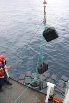 Crew members aboard the U.S. Coast Guard Escanaba (WMEC 907) hoisting bales of cocaine in the eastern Pacific. The drugs were offloaded at Port Everglades, Florida, August 5, 2025. (U.S. Coast Guard photo)