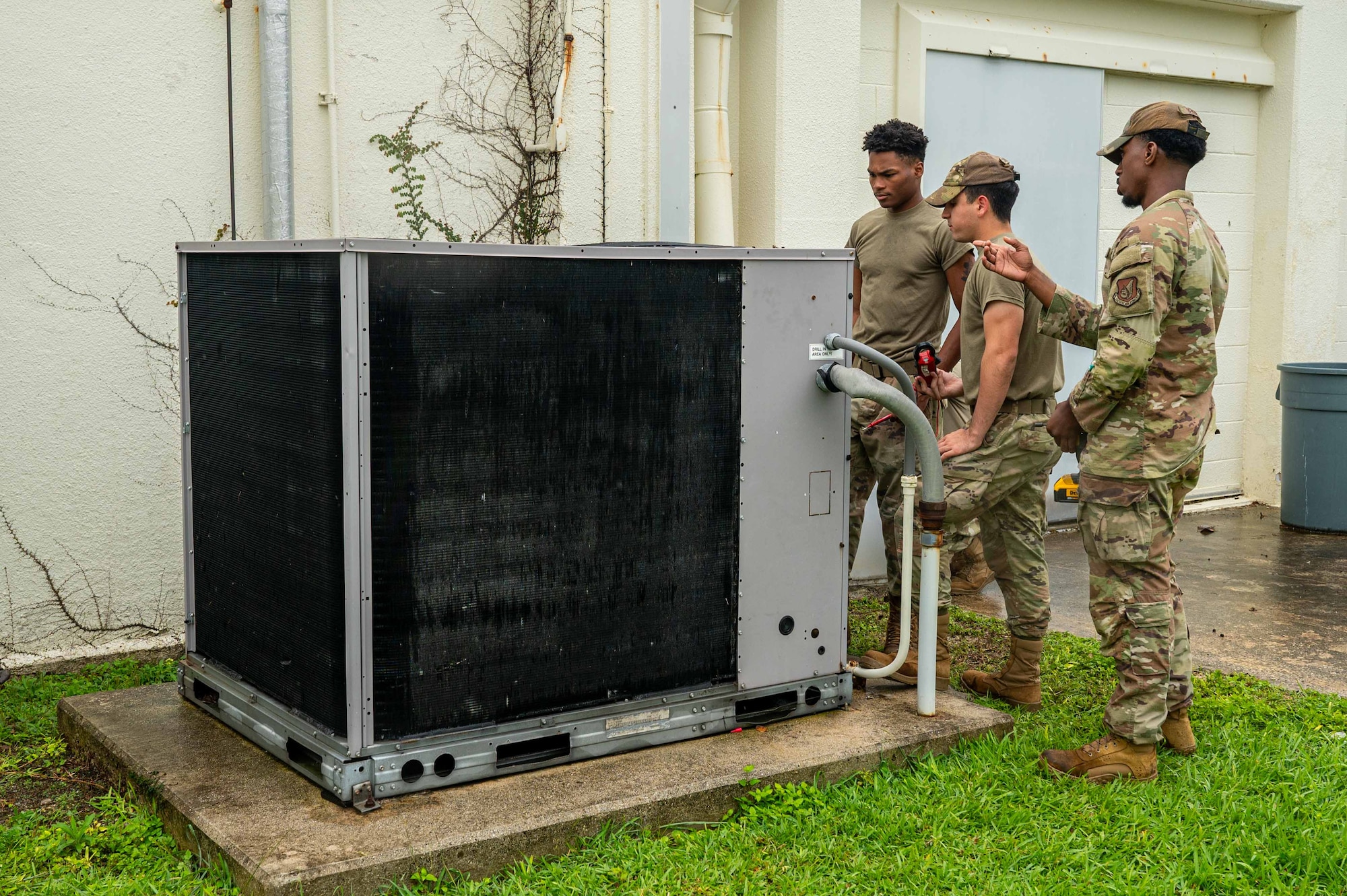 718th CES Airmen assess a condenser unit.