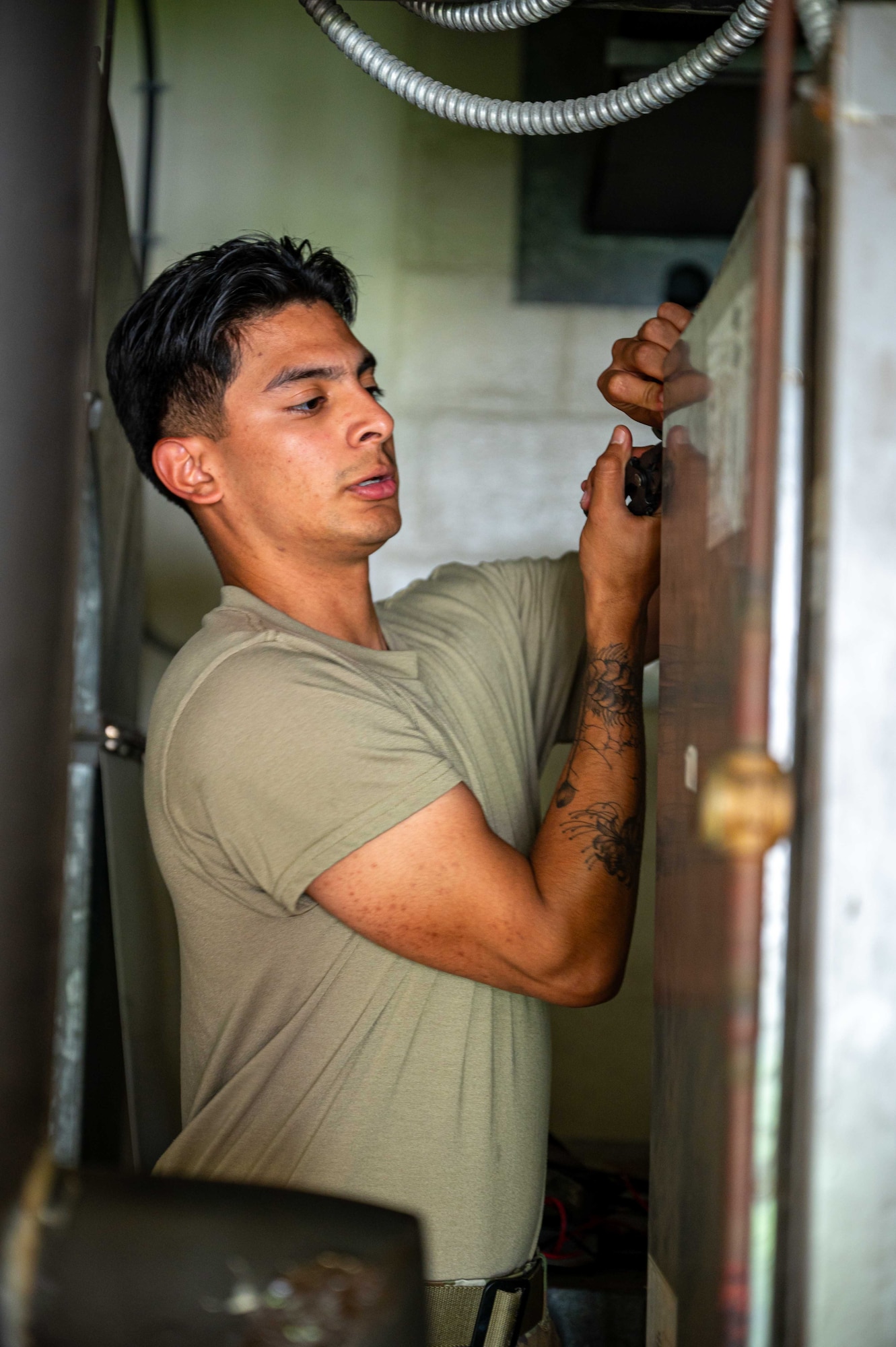 A 718th CES Airman reinforces a panel on an AC unit.