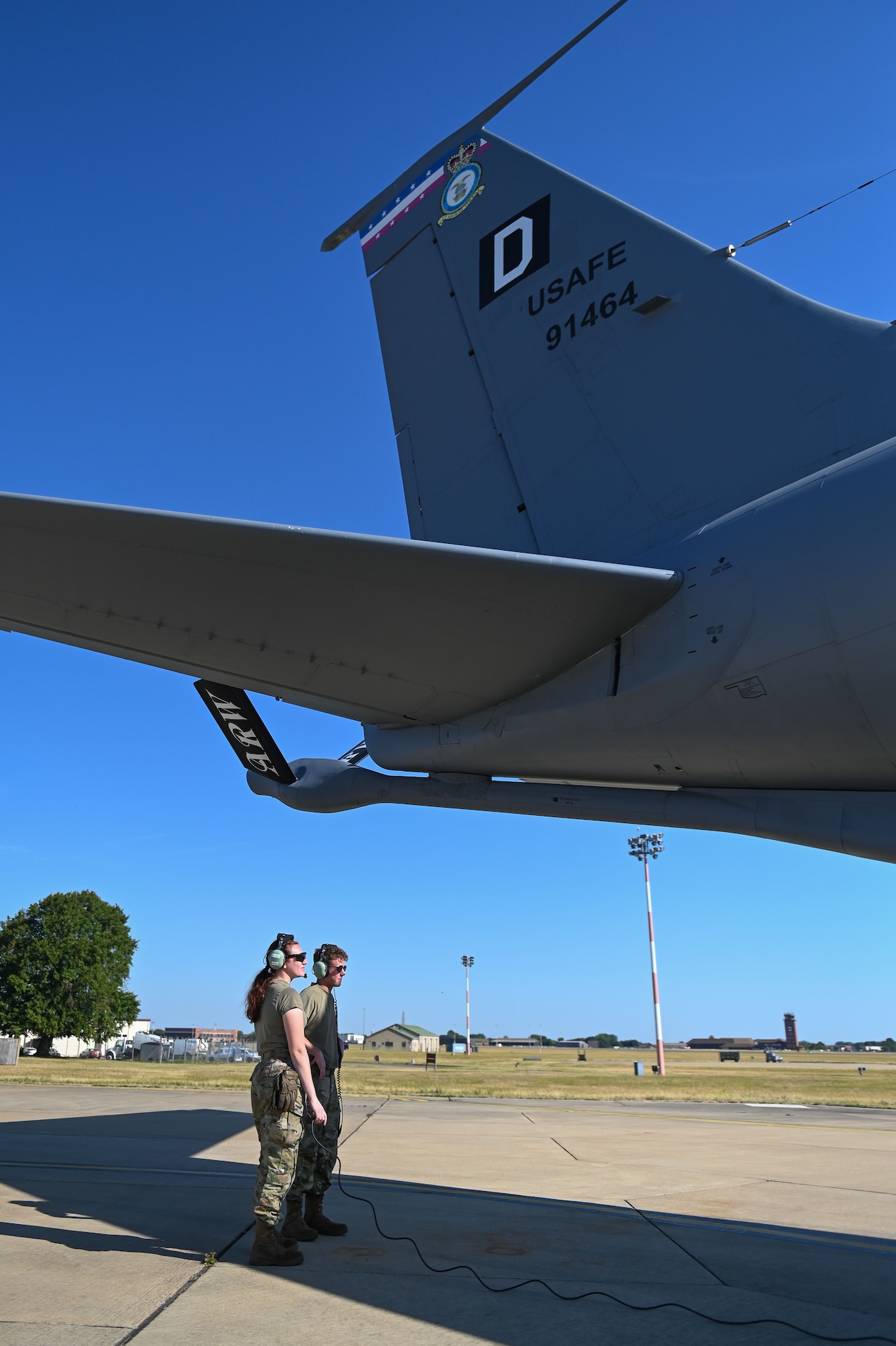 U.S. Air Force Airman 1st Class Connor Habusta, right, and Airman 1st Class Kayla Arnold, 100th Aircraft Maintenance Squadron crew chiefs, coordinate with the aircrew during pre-flight procedures at RAF Mildenhall, England, July 11, 2025.