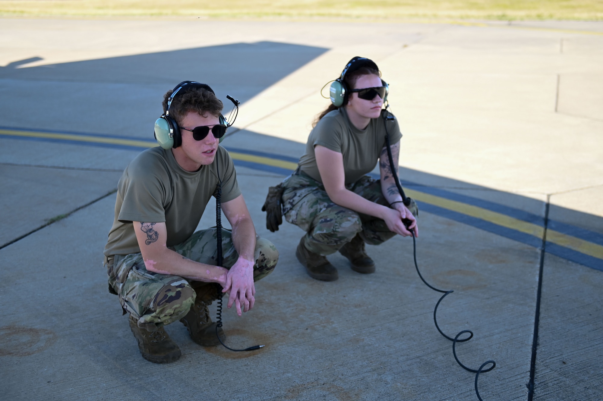 U.S. Air Force Airman 1st Class Connor Habusta, left, and Airman 1st Class Kayla Arnold, 100th Aircraft Maintenance Squadron crew chiefs, coordinate with the aircrew during KC-135 Stratotanker pre-flight procedures at RAF Mildenhall, England, July 11, 2025