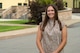 A woman poses for a photo outside.