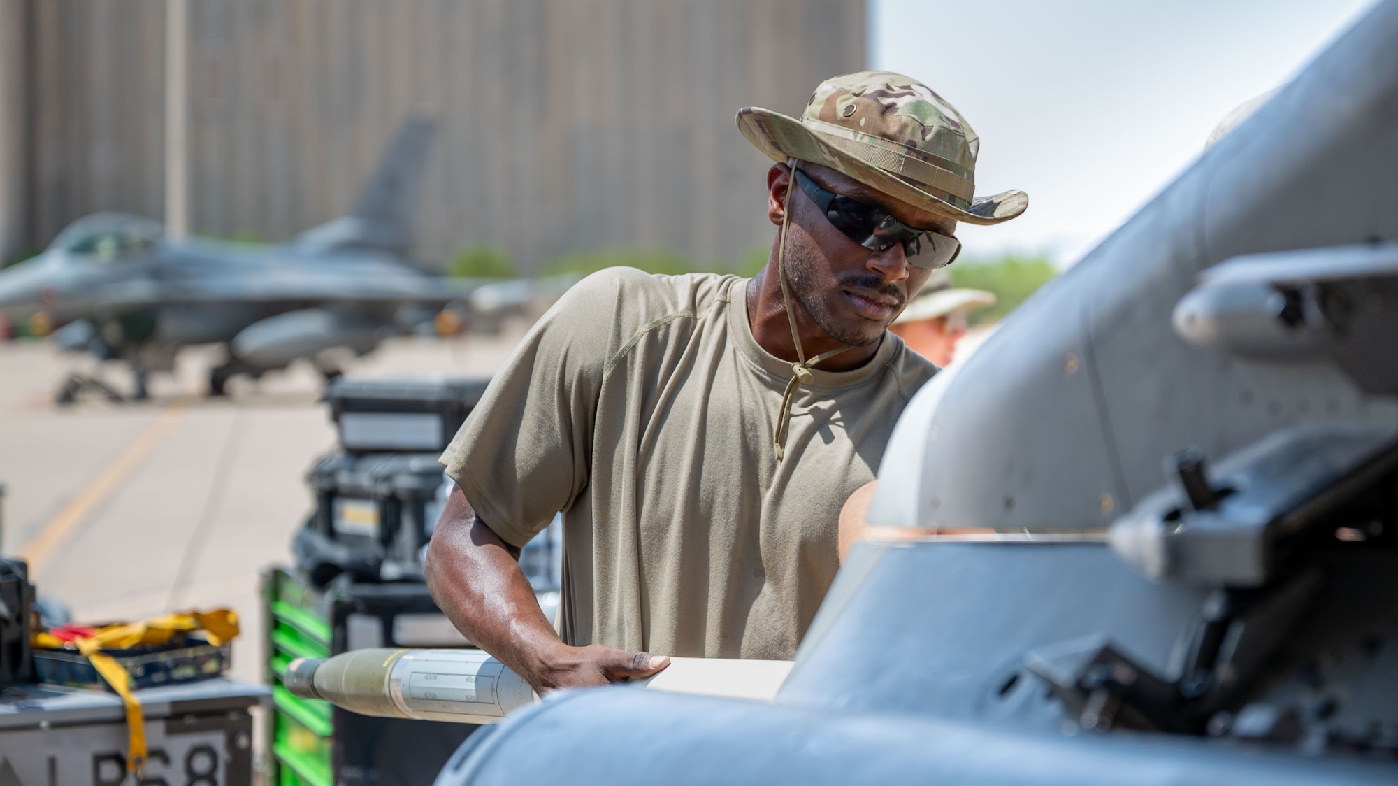 An Airman loads Advanced Precision Kill Weapon System rockets onto an F-16C Fighting Falcon.