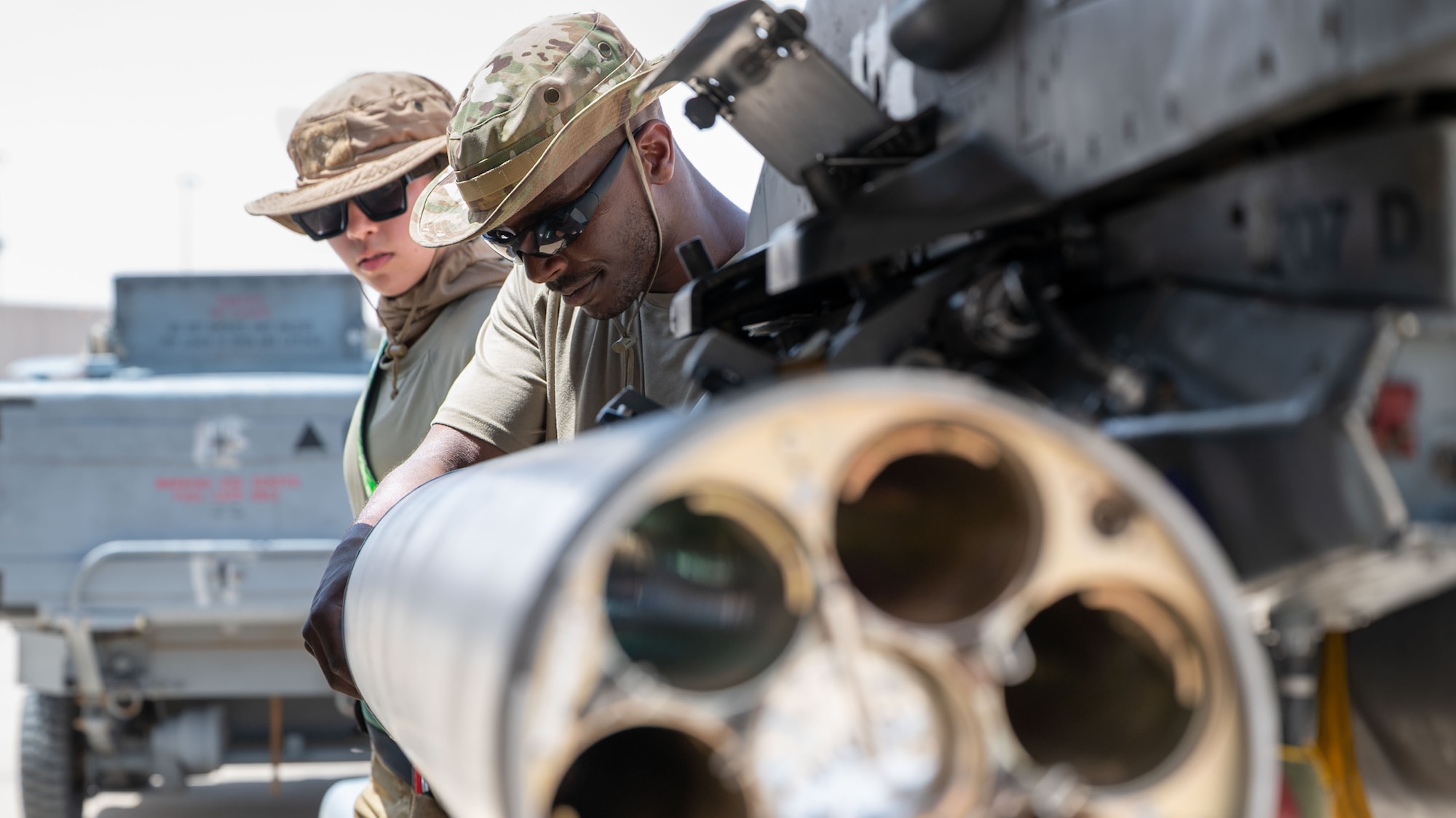 Two Airmen load an F-16C Fighting Falcon with Advanced Precision Kill Weapon System rockets.