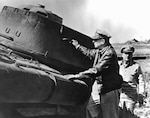 General of the Army Douglas MacArthur, Commanding General for the unified U.N. forces Aiding the Republic of Korea to repel the North Korean Communists, and a staff officer (right) inspecting a Communist tank, destroyed during the recent U.N. landings at Incho.