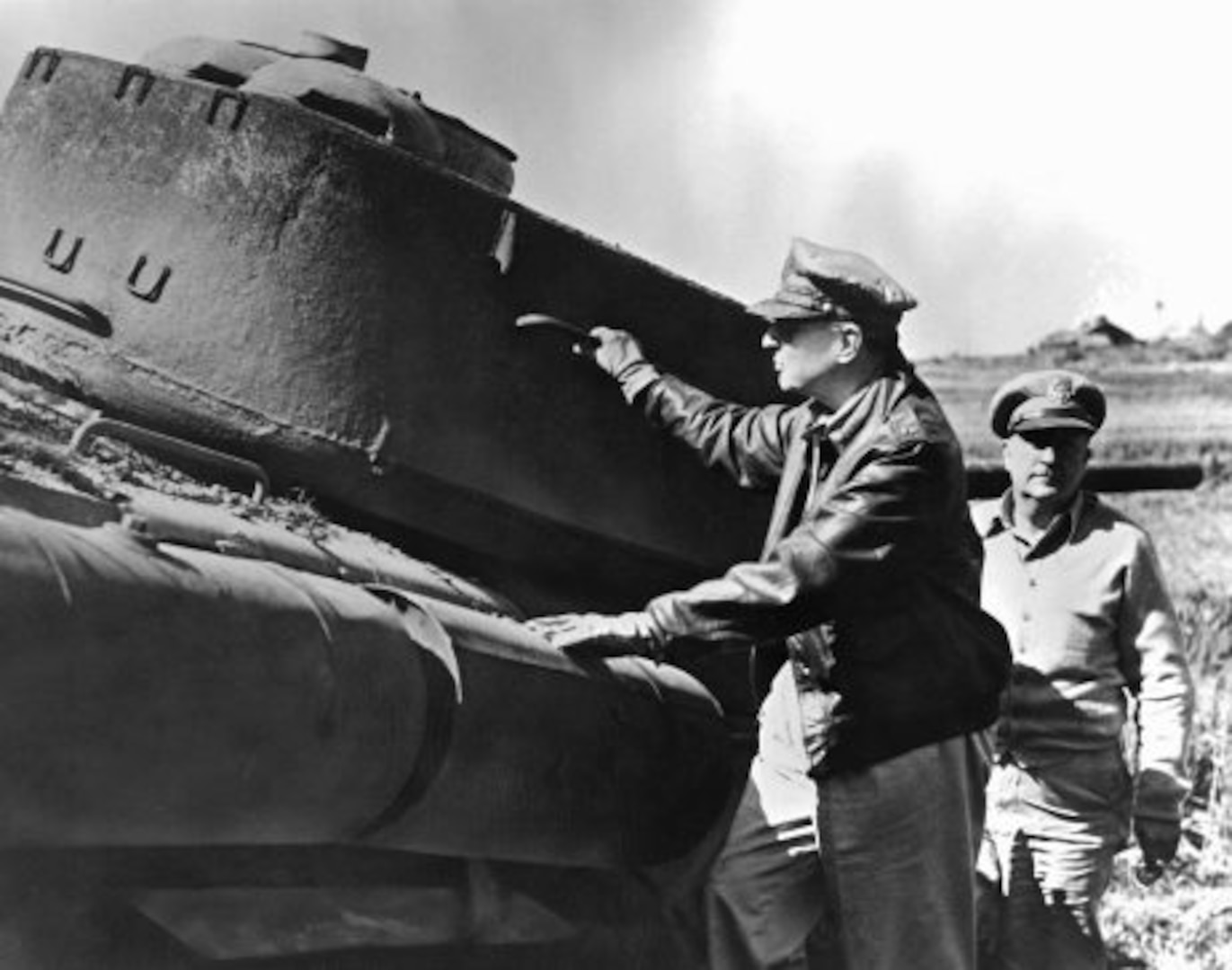 General of the Army Douglas MacArthur, Commanding General for the unified U.N. forces Aiding the Republic of Korea to repel the North Korean Communists, and a staff officer (right) inspecting a Communist tank, destroyed during the recent U.N. landings at Incho.