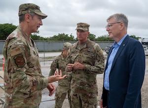 U.S. Air Force Gen. Kevin Schneider, Pacific Air Forces commander, talks to U.S. Army Brig. Gen. William Parker, commanding general of 94th Army Air and Missile Defense Command, and Secretary of the Air Force Troy Meink.