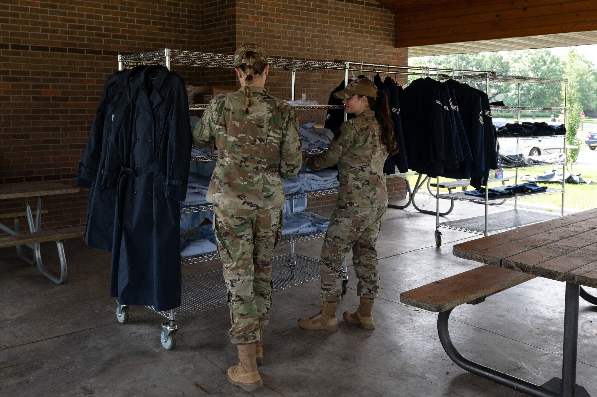 U.S Air Force Airman 1st Class Cailey Aandal, left, and Airman 1st Class Drew Bushard, right, 133rd Airlift Wing, look at clothes in St. Paul, Minn., June 7, 2025.