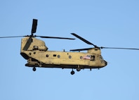 U.S. Army Sgt. Thriska Smith assigned to the Combat Aviation Brigade, 1st Armored Division displays an American flag to the crowd from a CH-47F Chinook helicopter during the 4th Annual Black Sea Air Show at Mihail Kogălniceanu International Airport, Romania, August 2, 2025. The air show displayed military aircraft, vehicles, and equipment from the United States, Romania, Italy, and Germany for exhibitors, visitors, and military delegations. This event provided an opportunity for Army aviation crews to demonstrate their elite flying skills and abilities while also demonstrating the U.S. commitment to providing forward deployed combat-credible forces in the region. (U.S. Army photo by Capt. Regina Koesters)