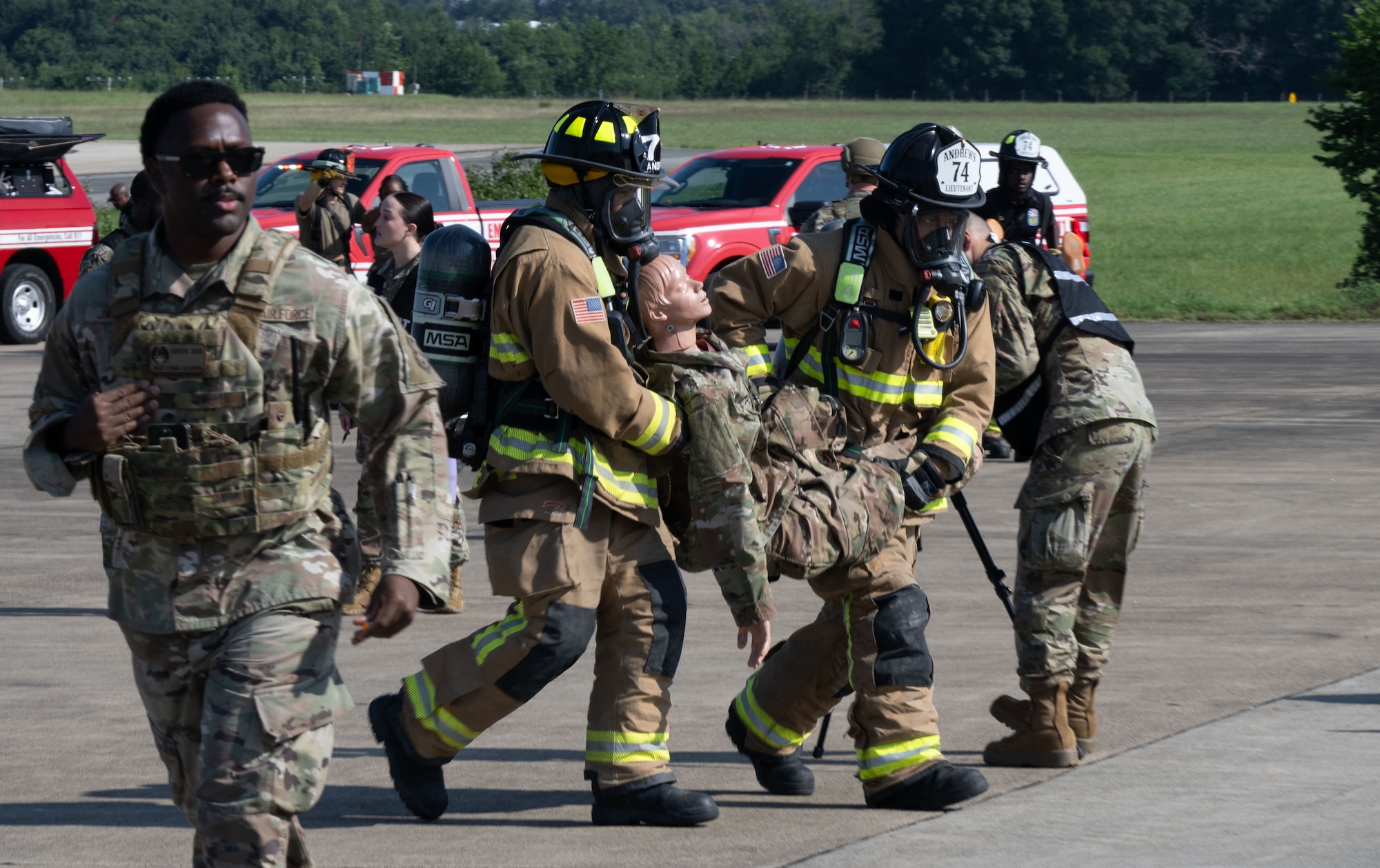 Firefighters with the Joint Base Andrews Fire Department simulate transporting an injured individual during a field training exercise at Joint Base Andrews, Md., July 24, 2025. First responders rehearsed rapid emergency response procedures during the hands-on scenario