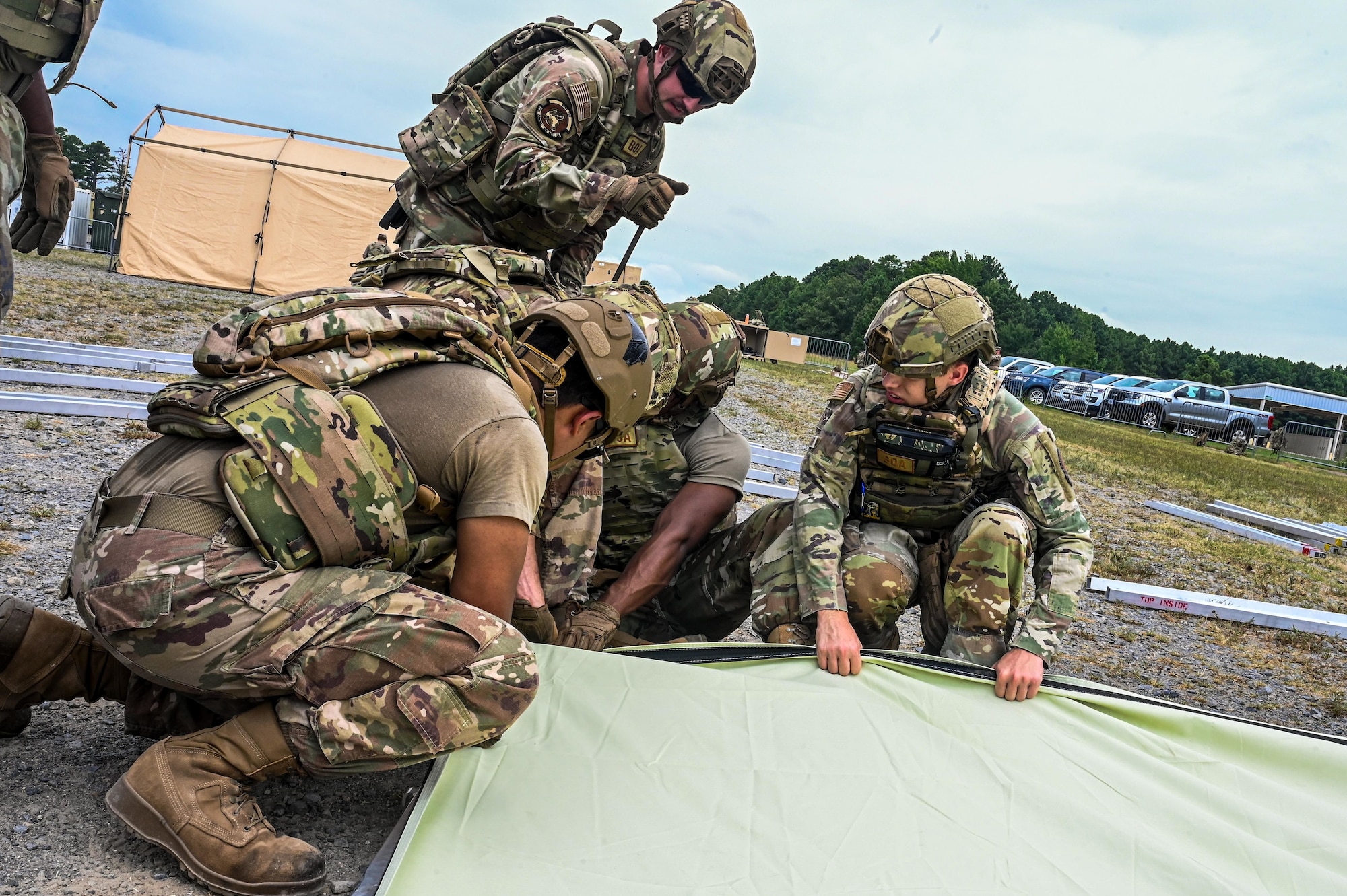 An Airman uses a sledgehammer outside while building a tent