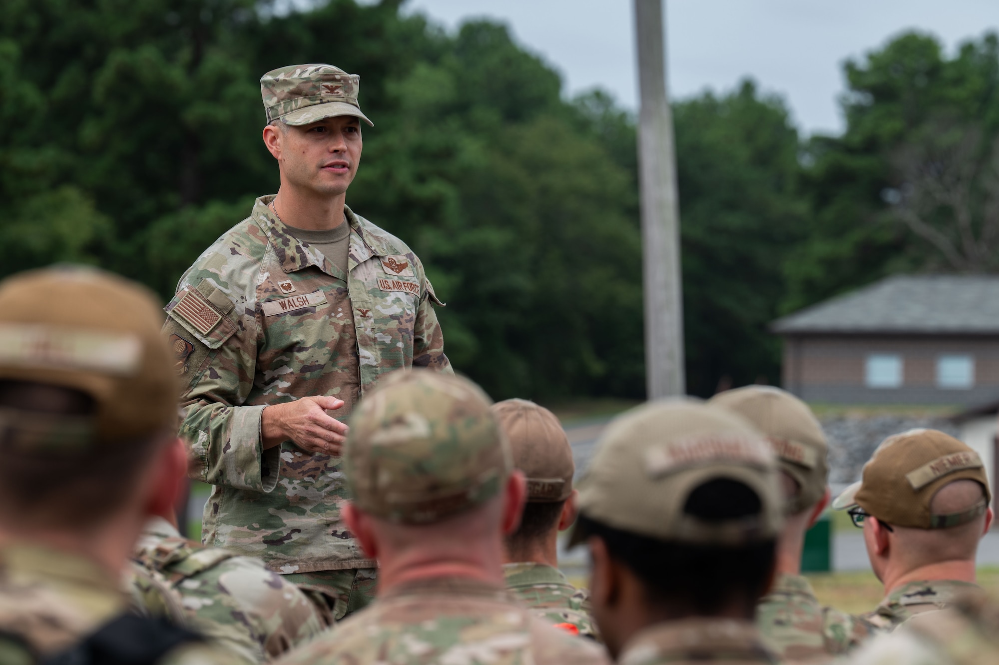 A command speaks to Airmen outside