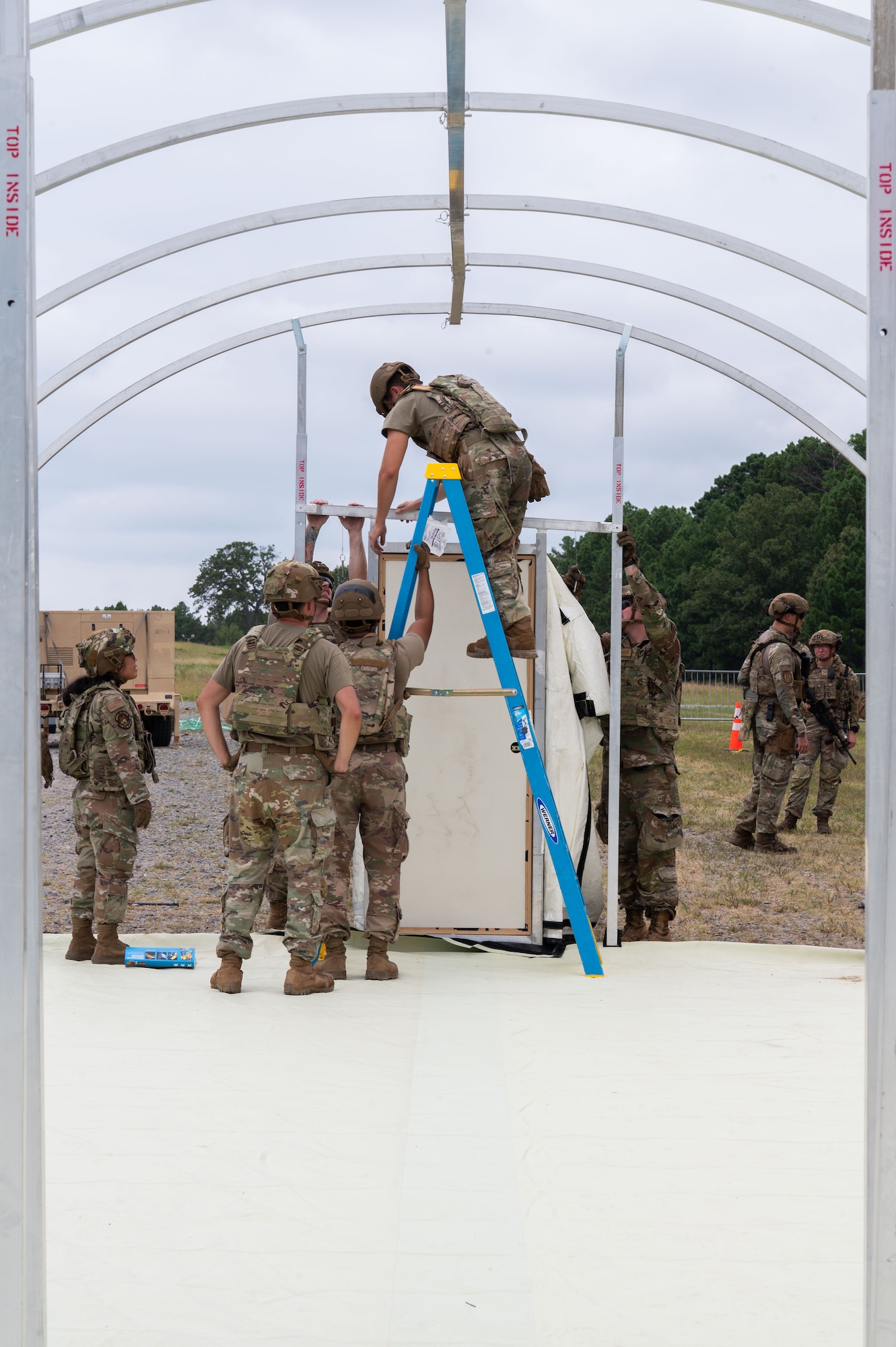 Airmen build a tent outside