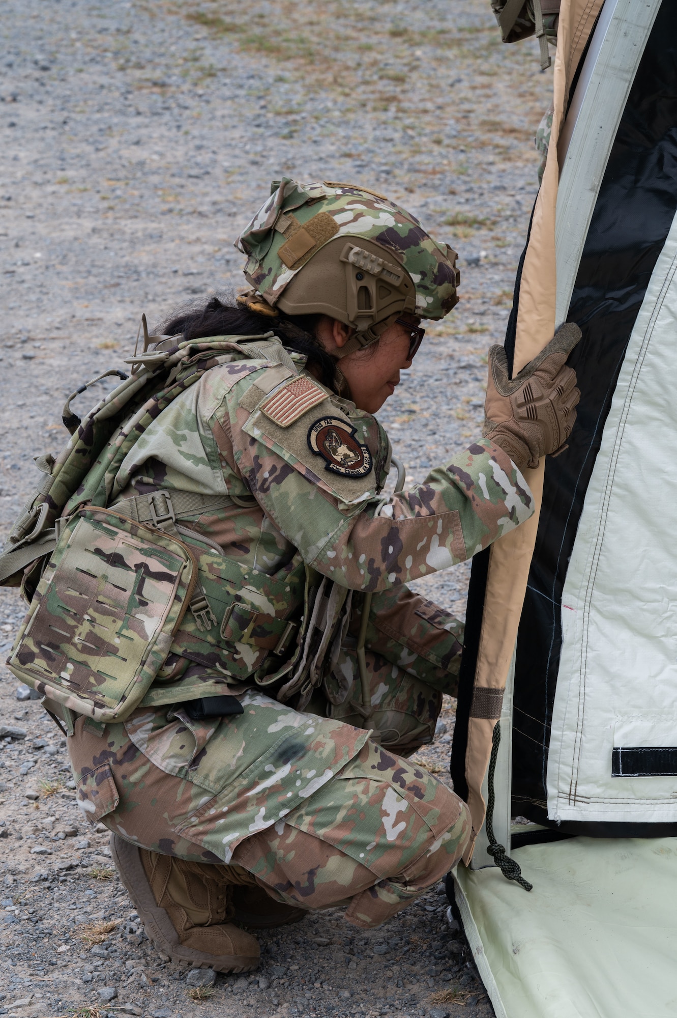 An Airman builds a tent outside