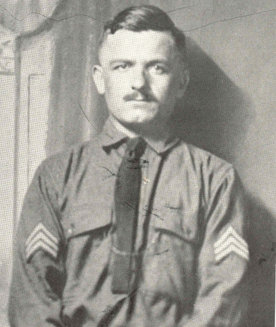 A soldier in uniform poses for a photo.