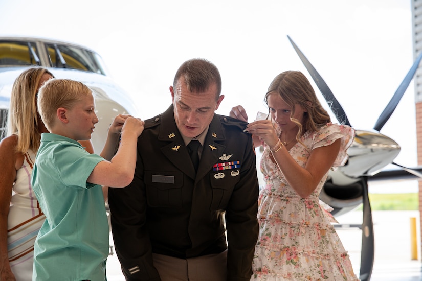 U.S. Army Col. Gabriel Spicer, commander of the 63rd Theater Aviation Brigade,  is pinned with his new rank by his children during his promotion ceremony at the Army Aviation Support Facility on Boone National Guard Center in Frankfort, Kentucky, July 24, 2025