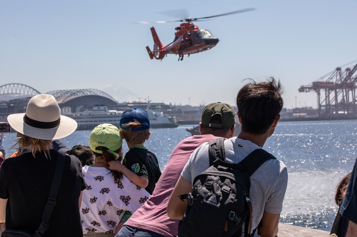 SEATTLE (July 29, 2025) Seattle residents observe an MH-60 Dolphin from the U.S. Coast Guard as it performs a search and rescue demonstration at Seattle Fleet Week 2025. Seattle Fleet Week is a time-honored celebration of the sea services and provides an opportunity for the citizens of Washington to meet Sailors, Marines and Coast Guardsmen, as well as witness firsthand the latest capabilities of today’s maritime services. (U.S. Navy photo by Mass Communication Specialist 1st Class Shane Bryan/Released)