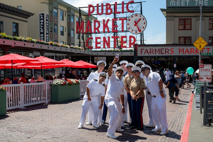 Sailors assigned to the guided missile destroyer USS Jack H. Lucas (DDG 125) and Marines with Headquarters and Service Battalion, 1st Marine Logistics Group, pose for a photo with U.S Navy Capt. Gervy Alota at Pike Place Market during Seattle Fleet Week, July 30, 2025. Seattle Fleet Week is a time-honored celebration of the sea services and provides an opportunity for the citizens of Washington to meet Sailors, Marines and Coast Guardsmen, as well as witness firsthand the latest capabilities of today’s maritime services. (U.S. Navy photo by Mass Communication Specialist 2nd Class Evan Diaz)