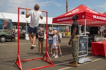 U.S. Marine Corps Gunnery Sgt. Devontay Dixon, right, a supply chief with Recruiting Station Seattle, interacts with expo attendees at the Fleet Week Expo during Seattle Fleet Week July 31, 2025. Seattle Fleet Week is a time-honored celebration of the sea services and provides an opportunity for the citizens of Washington to meet Sailors, Marines and Coast Guardsmen, as well as witness firsthand the latest capabilities of today's maritime services. (U.S. Marine Corps photo by Sgt. Bruin Largent)