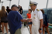 U.S Navy Capt. Gervy Alota shakes the hand of a veteran on the observation deck of the Seattle Space Needle during Seattle Fleet Week 2025. Seattle Fleet Week is a time-honored celebration of the sea services and provides an opportunity for the citizens of Washington to meet Sailors, Marines and Coast Guardsmen, as well as witness firsthand the latest capabilities. of today’s maritime services. (U.S. Navy photo by Mass Communication Specialist Seaman Joey Sitter)