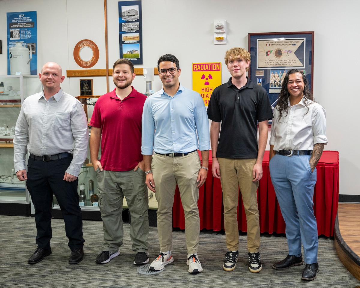 SMART Scholars Benjamin Lynch, Arthur Taylor, Enrique Medici, Jackson Neering, and Lindsey Ukishima, pose for a photo in the Air Force Technical Applications Center’s Heritage Room during their visit to the nuclear surveillance center of excellence June 26, 2025.  The students are part of the largest education-to-workforce initiative offered by DOD to address talent development and retention.  (U.S. Air Force photo by Matthew S. Jurgens)