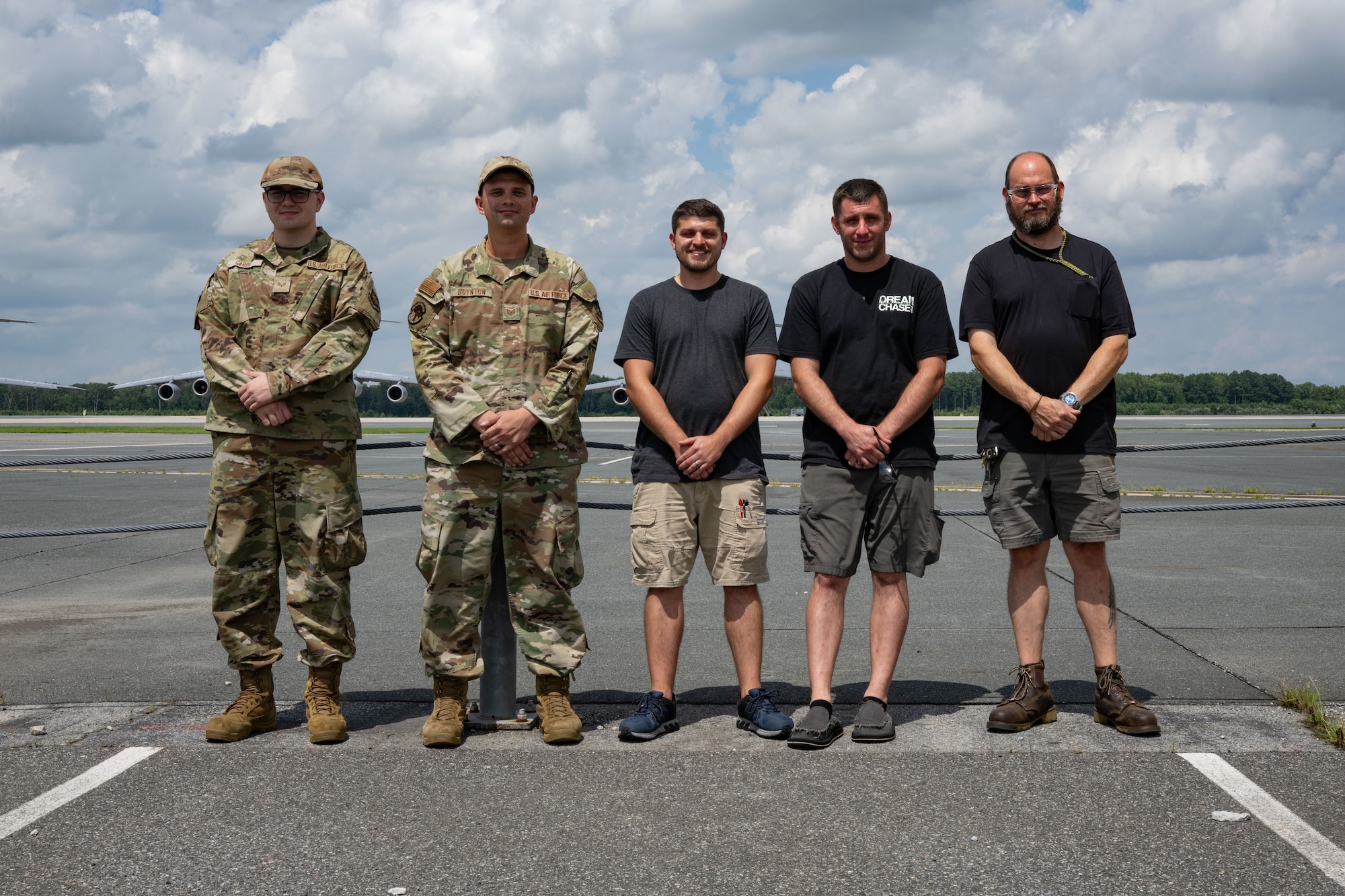 From left to right, U.S. Air Force Senior Airman Carter Garbe, 436th Maintenance Squadron Air Force Repair Enhancement Program technician, Tech. Sgt. Chandler Boynton, 436th MXS AFREP section chief, Austin Wilt, Joshua Turnbull and Cody Garland, 436th MXS avionics technicians, stand for a photo in front of the flight line at Dover Air Force Base, Delaware, July 16, 2025. The AFREP is a program that rescues unserviceable aircraft parts and electronics, repairing and refurbishing them to like-new condition. (U.S. Air Force photo by Airman 1st Class Liberty Matthews)