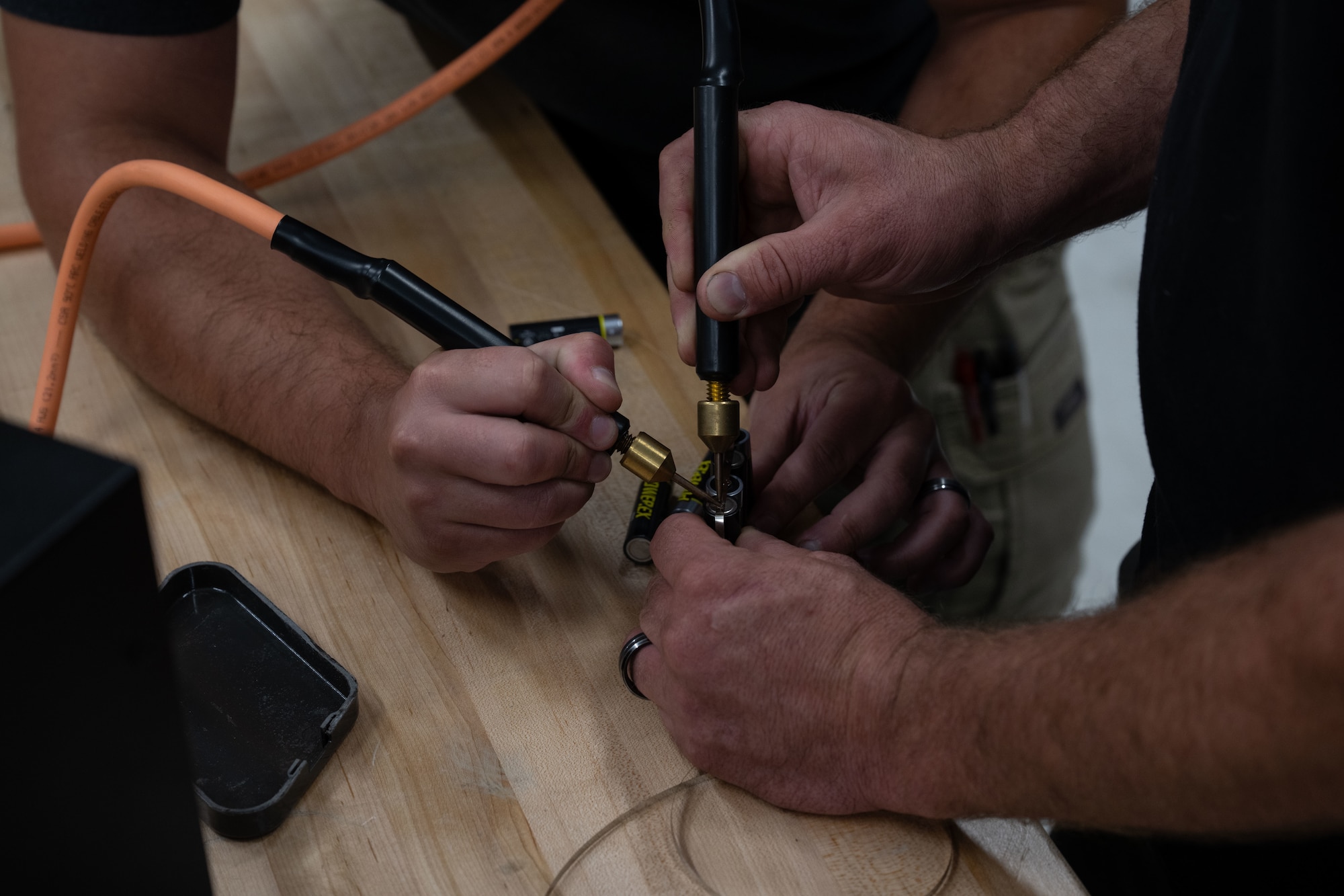Joshua Turnbull, right, and Austin Wilt, 436th Maintenance Squadron avionics technicians, solders batteries together with nickel strips at the Air Force Repair Enhancement Program shop on Dover Air Force Base, Delaware, July 16, 2025. This modified battery will serve as a replacement power source that is no longer produced for a tool used for testing equipment on aircraft. (U.S. Air Force photo by Airman 1st Class Liberty Matthews)