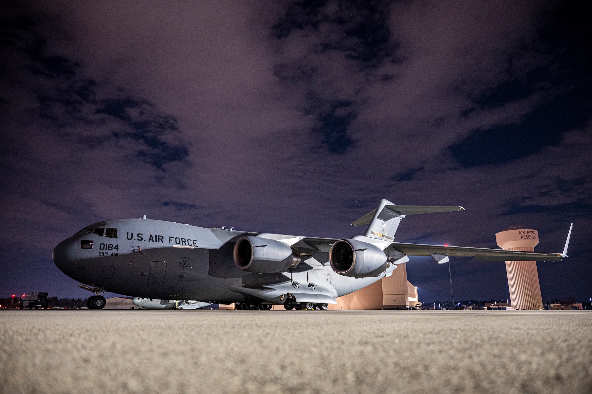 a c-17 globemaster 3 sits against the night sky