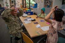 Boatswain’s Mate 1st Class Nathan Burnau, from Barstow, Calif., assigned to the Arleigh Burke-class guided missile destroyer USS Jack H. Lucas (DDG 125), does arts and crafts with patients at the Seattle Children’s Hospital during Seattle Fleet Week 2025. Seattle Fleet Week is a time-honored celebration of the sea services and provides an opportunity for the citizens of Washington to meet Sailors, Marines and Coast Guardsmen, as well as witness firsthand the latest capabilities. of today’s maritime services. (U.S. Navy photo by Mass Communication Specialist Seaman Joey Sitter)