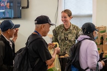 Ensign Kathe Neumeyer assigned to amphibious transport dock ship USS Somerset (LPD 25) serves guests during a food bank at Providence Regina House as part of Seattle Fleet Week, Aug. 2, 2025. Seattle Fleet Week is a time-honored celebration of the sea services and provides an opportunity for the citizens of Washington to meet Sailors, Marines and Coast Guardsmen, as well as witness firsthand the latest capabilities of today’s maritime services. (U.S. Navy photo by Mass Communication Specialist 2nd Class Evan Diaz)