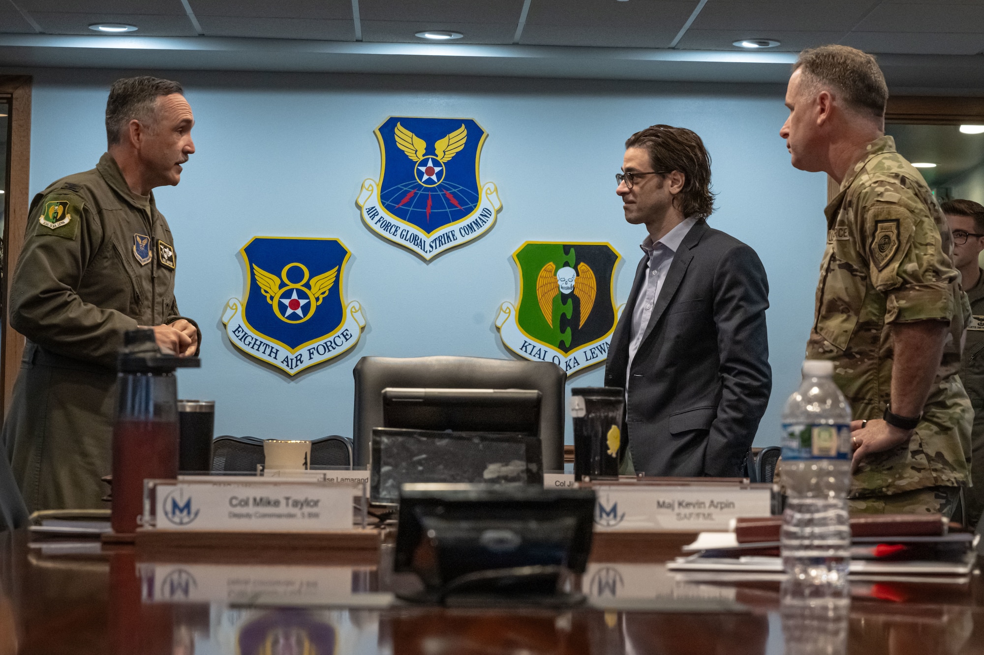 U.S. Air Force Col. Jesse Lamarand, 5th Bomb Wing commander (left), and U.S. Air Force Col. James Schlabach, 91st Missile Wing commander (right), provide a welcome brief to Robert Karem, congressional staff delegate (center), at Minot Air Force Base, Aug. 5, 2025. The brief covered information about Minot AFB and its vital mission of deterrence.
