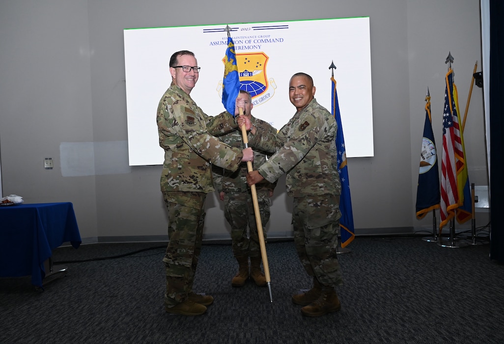 Col. Douglas C. Jeffrey IV, 433rd Airlift Wing commander, passes the 433rd Maintenance Group guidon to Col. Michael H. M. Egbalic, incoming 433rd Maintenance Group commander, during an assumption of command ceremony at Joint Base San Antonio-Lackland, Texas, Aug. 2, 2025.