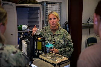 250730-N-KC192-2064 FORT RUCKER, Ala. (July 30, 2025) Lt. Cmdr. Chelsea Godfrey, a Joint Enroute Care Course (JECC) instructor assigned to the Department of Aviation Medicine, explains how to operate a ventilator to students as part of the JECC on Fort Rucker, Alabama, July 30, 2025. The purpose of JECC training is to operationalize clinical skills of servicemembers and introduce them to a standardized methodology for providing critical care while transporting a patient through the battle space during deployment as members of teams operating in austere environments. (U.S. Navy photo by Mass Communication Specialist 2nd Class Levi Decker)