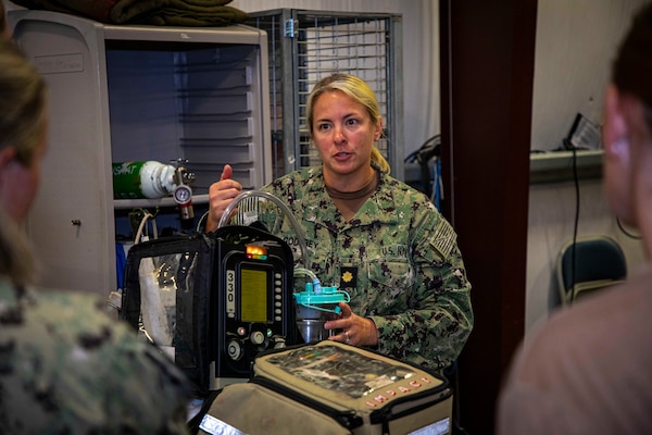 250730-N-KC192-2064 FORT RUCKER, Ala. (July 30, 2025) Lt. Cmdr. Chelsea Godfrey, a Joint Enroute Care Course (JECC) instructor assigned to the Department of Aviation Medicine, explains how to operate a ventilator to students as part of the JECC on Fort Rucker, Alabama, July 30, 2025. The purpose of JECC training is to operationalize clinical skills of servicemembers and introduce them to a standardized methodology for providing critical care while transporting a patient through the battle space during deployment as members of teams operating in austere environments. (U.S. Navy photo by Mass Communication Specialist 2nd Class Levi Decker)