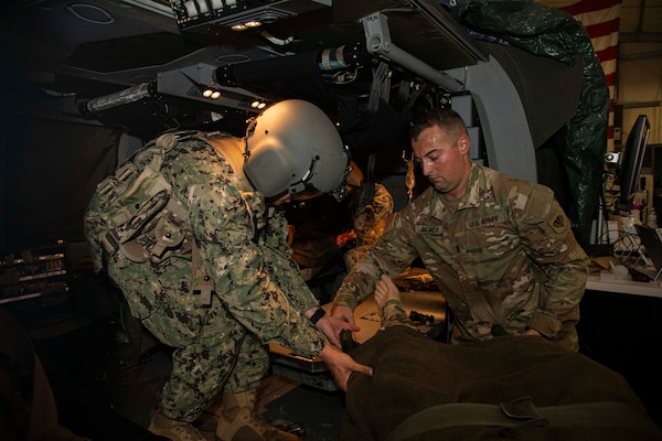 250731-N-KC192-1056 FORT RUCKER, Ala. (July 31, 2025) Hospital Corpsman 1st Class Axel Narvaez, assigned to Naval Medical Forces Atlantic, receives a simulated casualty during a point of injury simulation as part of the Joint Enroute Care Course (JECC) on Fort Rucker, Alabama, July 31, 2025. The purpose of JECC training is to operationalize clinical skills of servicemembers and introduce them to a standardized methodology for providing critical care while transporting a patient through the battle space during deployment as members of teams operating in austere environments. The course enhances joint interoperability by bringing together personnel from across the services to operationalize clinical skills and strengthen integrated medical response during deployment. (U.S. Navy photo by Mass Communication Specialist 2nd Class Levi Decker)