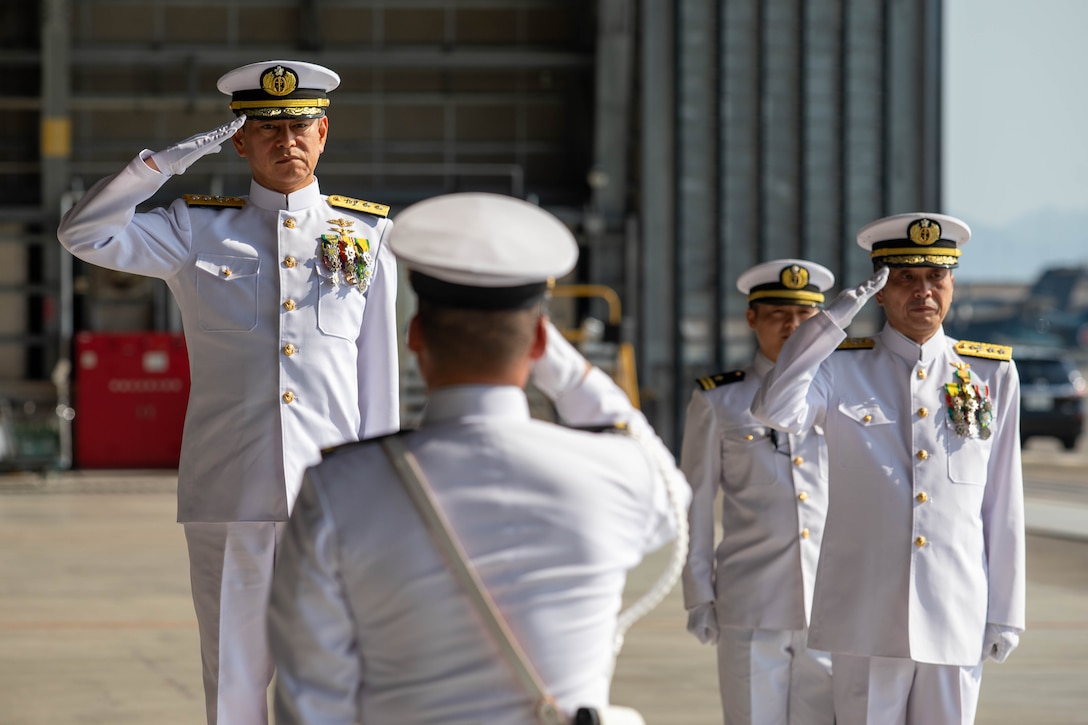 Rear Admiral Katasuhi Ohkubo, left, oncoming commander, Fleet Air Wing 31, assumes command of FAW 31 from Rear Adm. Ichiro Ishikawa, right, outgoing commander, Fleet Air Wing 31, at Marine Corps Air Station Iwakuni, Japan, August 1, 2025. FAW 31 held the change of command ceremony to formally transfer command from Rear Admiral Ichiro Ishikawa to Rear Admiral Katasuhi Ohkubo, symbolizing the shift in leadership, authority, and responsibility for the command. (U.S. Marine Corps photo by Lance Cpl. Micah Taylor)