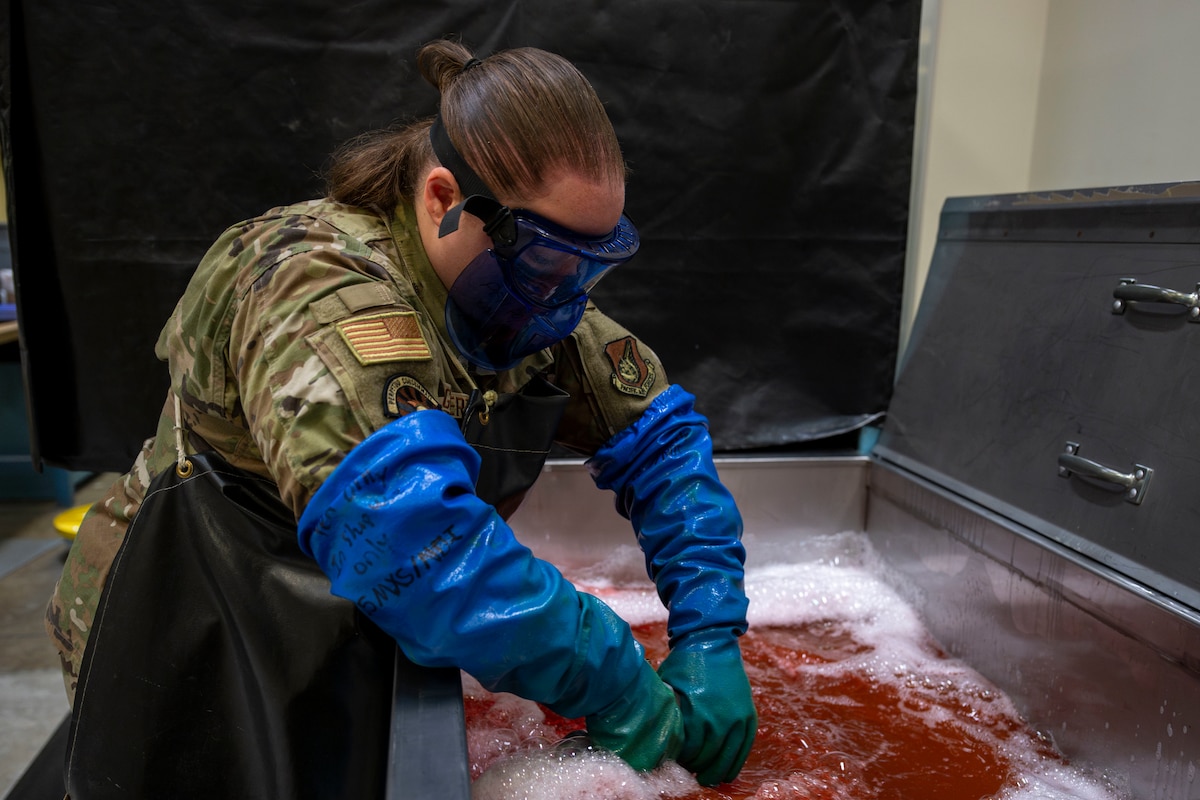 U.S. Air Force Staff Sgt. Estella Gilbert, 35th Maintenance Squadron Nondestructive Inspection supervisor, washes a mechanical component before inspection at Misawa Air Base, Japan, Aug. 4, 2025