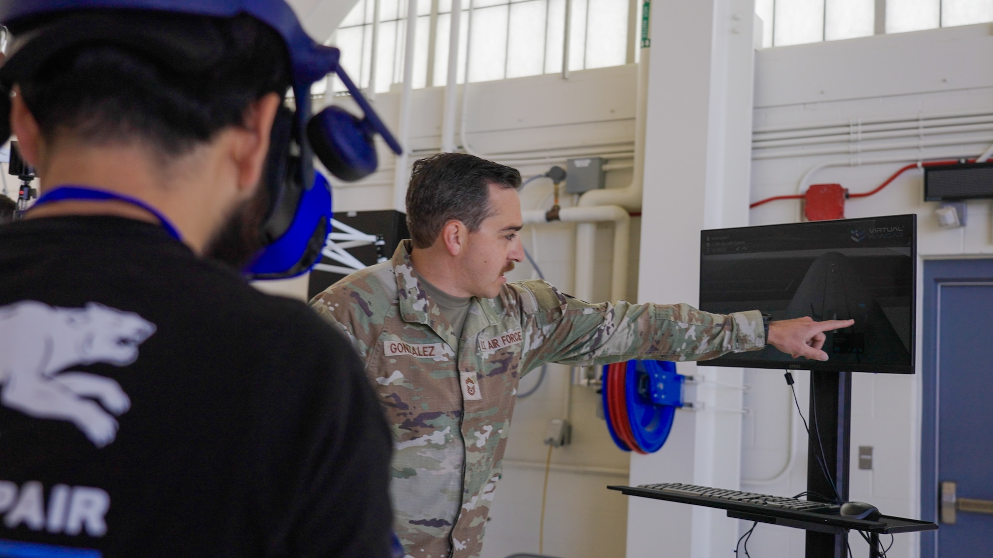 Chief Master Sgt. Gonzalez, 349th Aircraft Maintenance Squadron senior enlisted leader, demonstrates virtual reality training capabilities to an attendee during the Travis Air Reserve Experience 2025 at Travis Air Force Base, Calif., Aug. 3, 2025. The Travis Air Reserve Experience is a recruiting event designed to give community members an opportunity to interact directly with Reserve Airmen, learn about career paths, and explore the mission of the 349th Air Mobility Wing.