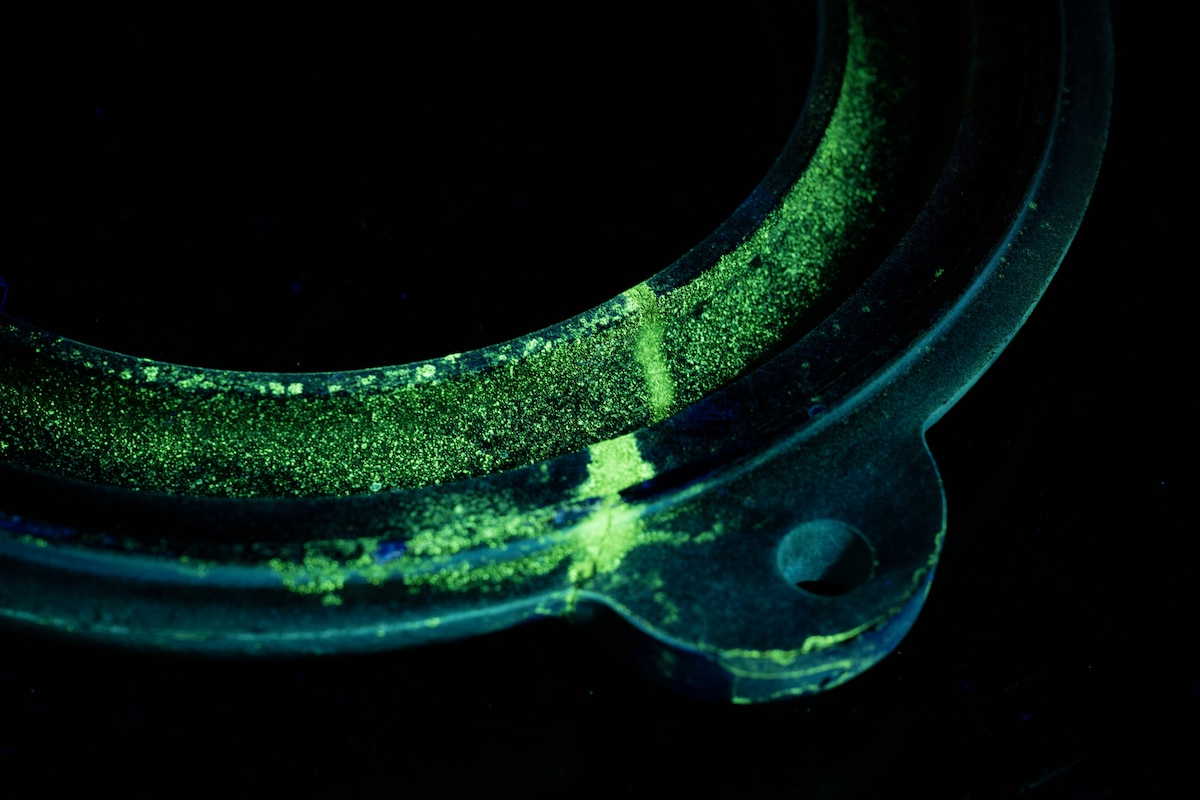 A mechanical component is inspected under black light at Misawa Air Base, Japan, Aug. 4, 2025.