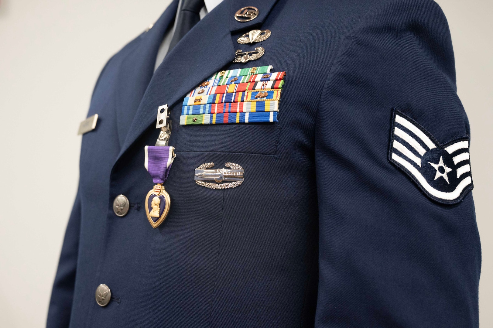 A closeup of an airman's uniform is shown with a Purple Heart medal.