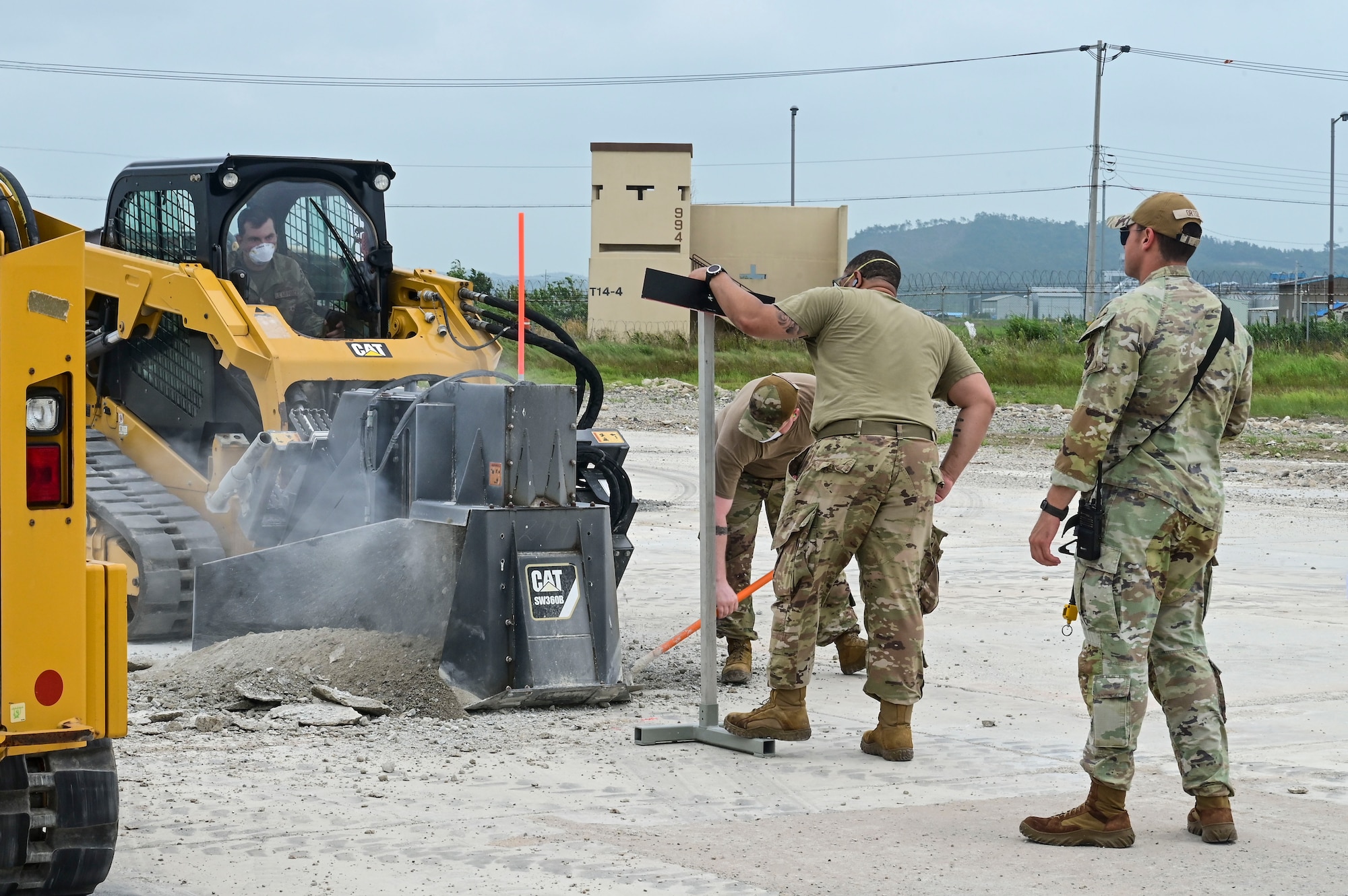 Airmen from the 8th Civil Engineer Squadron move debris away from a pavement saw during exercise Beverly Sentinel 25-3 at Kunsan Air Base, Republic of Korea, Aug. 6, 2025. The saw was used to cut out a measured section of the flightline where the Red Devils practiced repairing airfield damage.