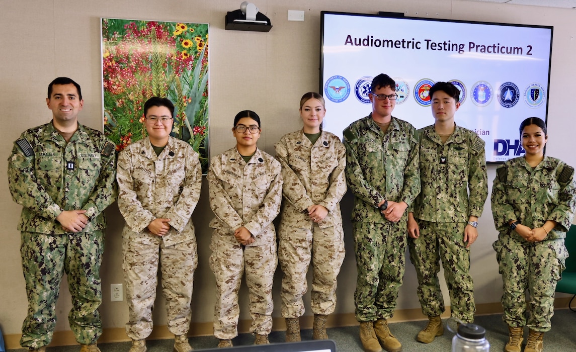 Lt. Christopher Barajas (left), Audiology Department Head at NMRTC Twentynine Palms, stands with the six Sailors who passed the Audiology Technician Course on the final day of training, July 25, 2025. The course equips corpsmen and civilian health technicians with the specialized skills and certification needed to conduct hearing screenings, interpret audiograms, and identify potential issues that could impact a service member’s readiness. With more than 12,000 active-duty personnel enrolled in the installation’s hearing conservation program, audiology plays a vital role in protecting one of the most critical senses required for operational effectiveness—hearing. From early detection of hearing loss to timely medical referrals, properly trained audio technicians help ensure warfighters remain fit for duty. By producing certified professionals who understand both the technical and clinical aspects of hearing health, the course directly supports Navy Medicine’s mission to sustain a medically ready force