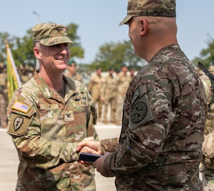 U.S. Army Col. William Cox, exercise co-director, receives an award from Georgian Maj. Gen. Irakli Chichinadze, Deputy Chief of Defence of Georgia, during the Agile Spirit closing ceremony at Vaziani Training Area, Georgia, Aug. 6, 2025.