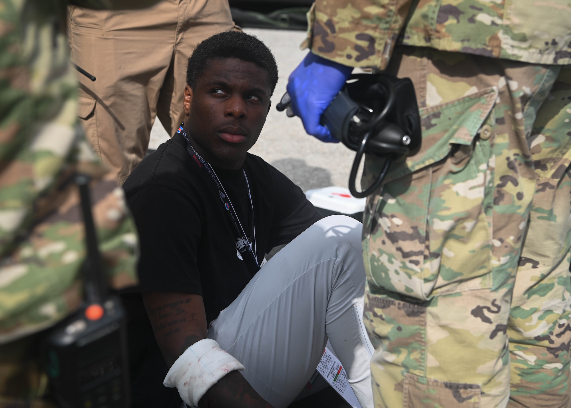 Airman Keoni Taylor, 55th Security Forces Squadron defender, sits on a gurney after being treated for a simulated arm injury during a Major Accident Response Exercise on Offutt Air Force Base, Nebraska, July 30, 2025. Firefighters, medical staff, and security forces members, among others, were on scene to respond to the simulated fuel spill and tend to the victims. (U.S. Air Force photo by Daniel Martinez)