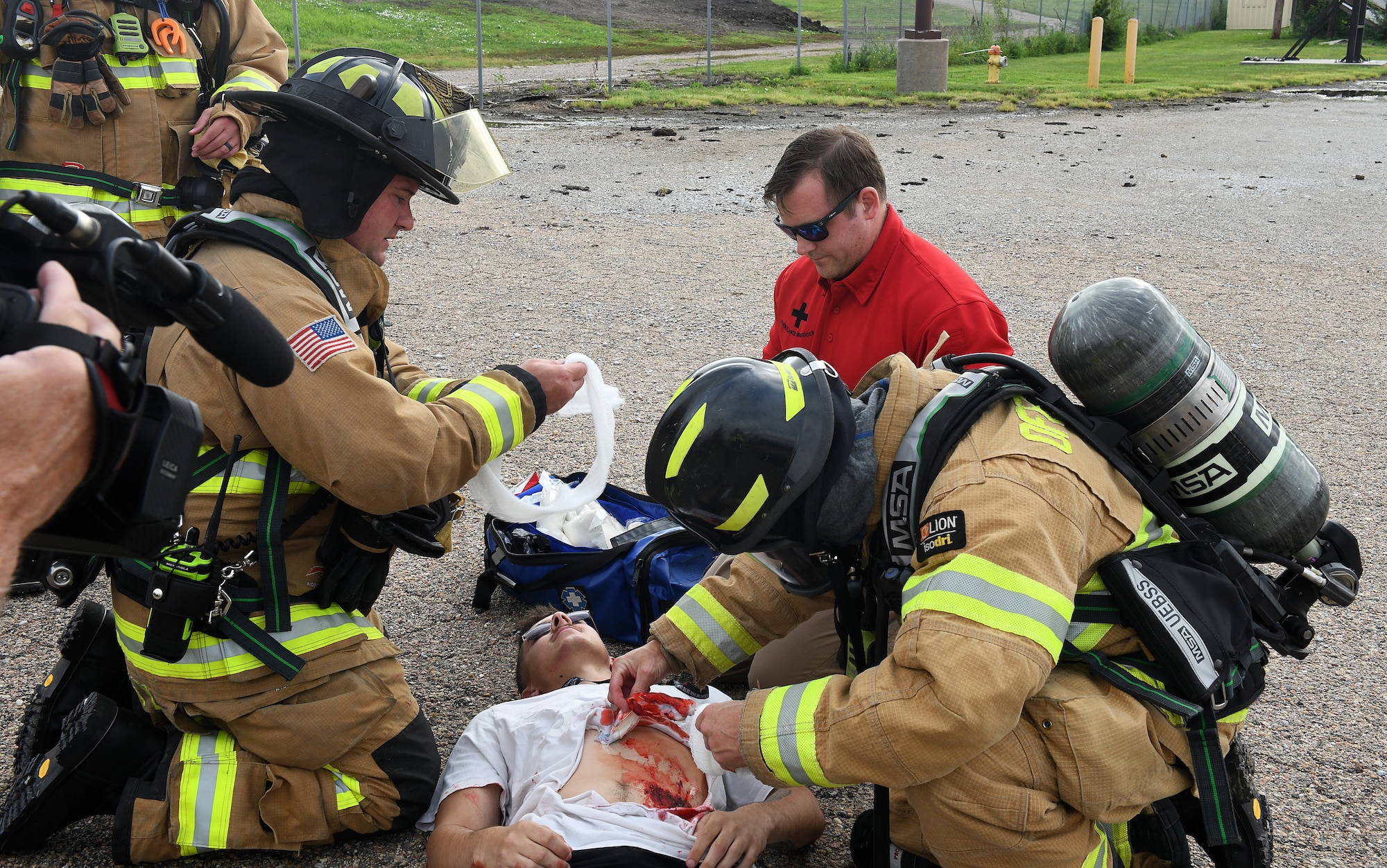 Offutt firefighters and 55th Medical Group staff tend to a simulated injured victim on the flightline during a Major Accident Response Exercise at Offutt Air Force Base, Nebraska, July 30, 2025. Airmen wore prosthetics to simulate realistic bloody injuries to help emergency crews respond to realistic casualties. (U.S. Air Force photo by Charles Haymond)