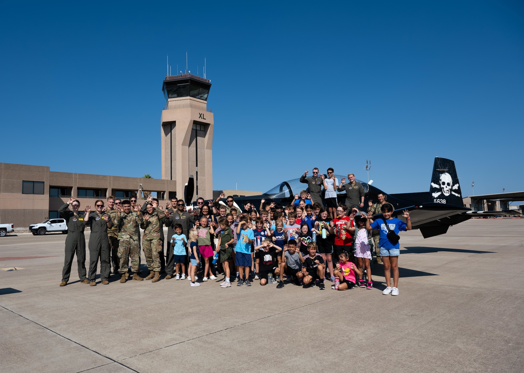 A group photo of Tiger for a Day participants and organizers at Laughlin Air Force Base, Texas, Aug. 5, 2024. The event concluded outside on the flightline in front of the T-6 FAIP tail. (U.S. Air Force photo by Airman 1st Class Harrison Sullivan)