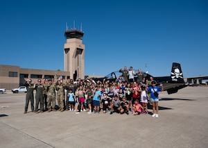 A group photo of Tiger for a Day participants and organizers at Laughlin Air Force Base, Texas, Aug. 5, 2024. The event concluded outside on the flightline in front of the T-6 FAIP tail. (U.S. Air Force photo by Airman 1st Class Harrison Sullivan)