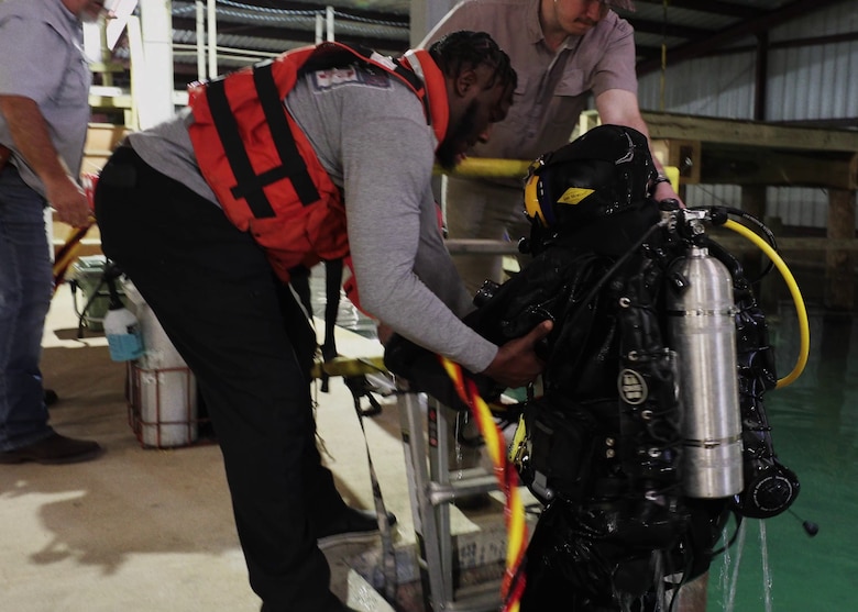 A diver with the U.S. Army Engineer Research and Development Center’s dive team ascends a ladder while participating in a drysuit training exercises.